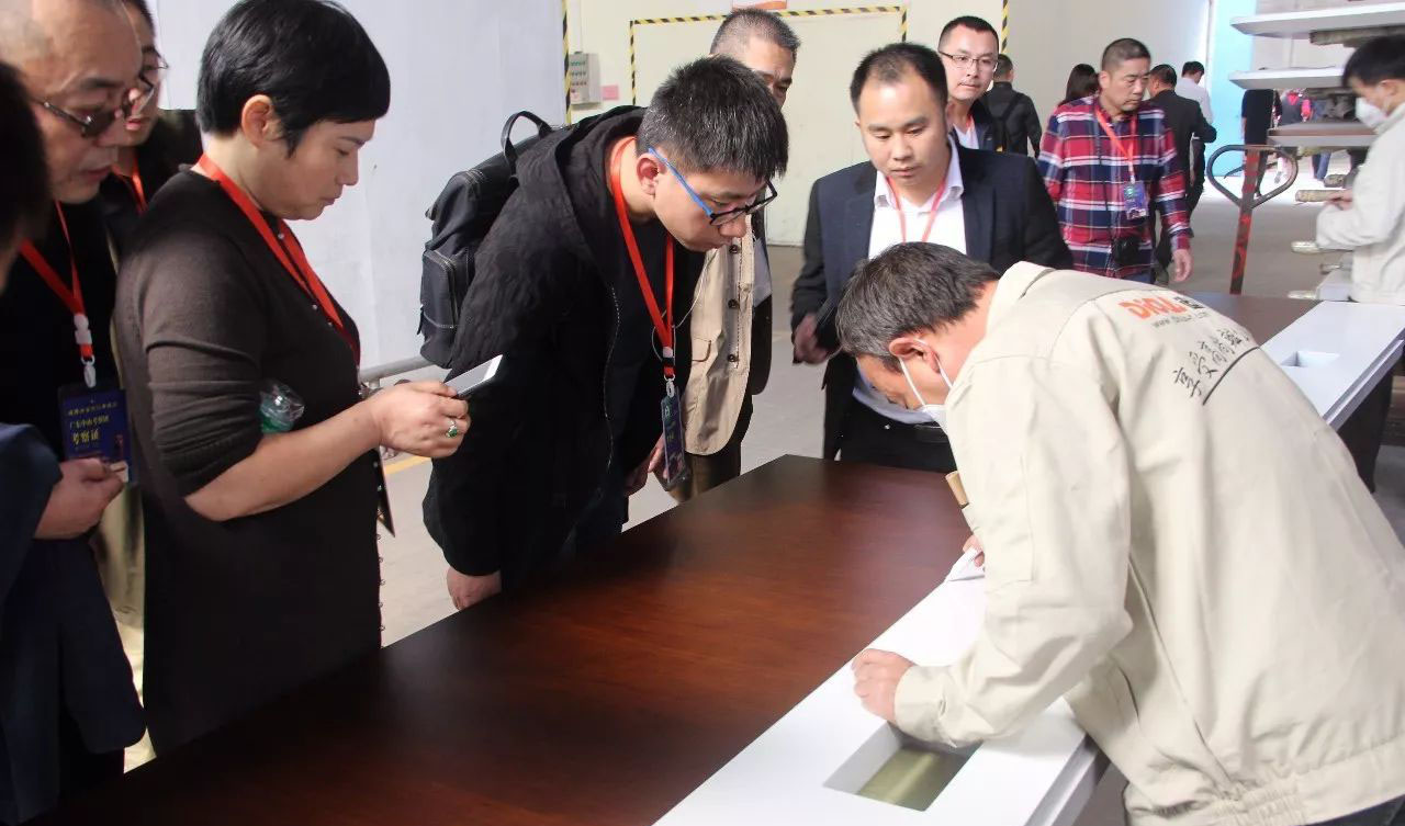 考察團認真觀看油漆工師傅施工，並不時提出自己企業生產所遇到問題，老師傅都一一認真回答。